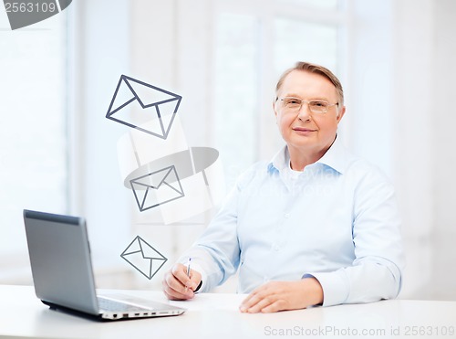 Image of old man in eyeglasses filling a form at home