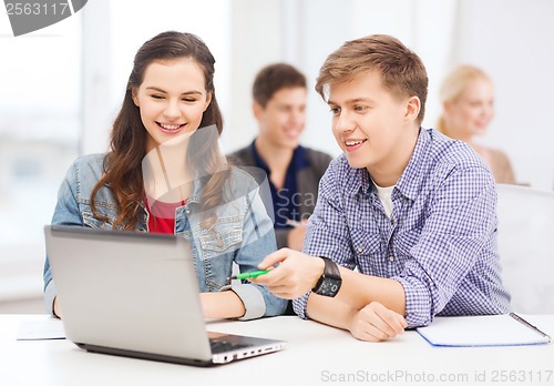 Image of students with laptop and notebooks at school