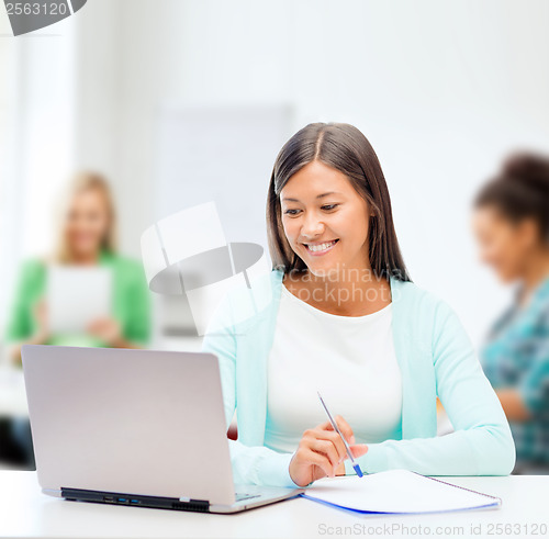 Image of asian businesswoman with laptop and documents