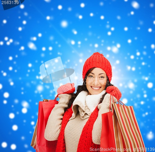 Image of smiling woman in warm clothers with shopping bags