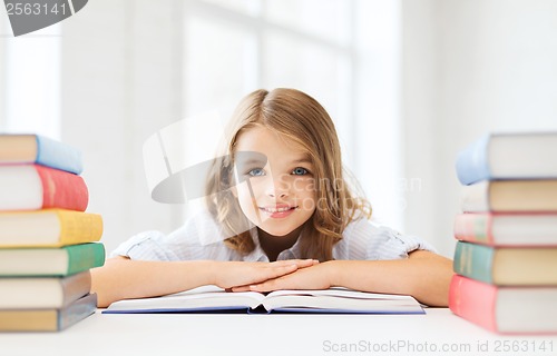 Image of smiling little student girl with many books