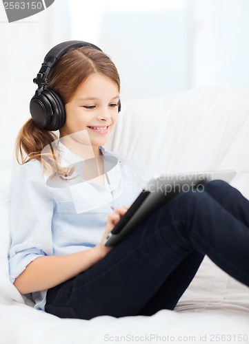 Image of girl with tablet pc and headphones at home