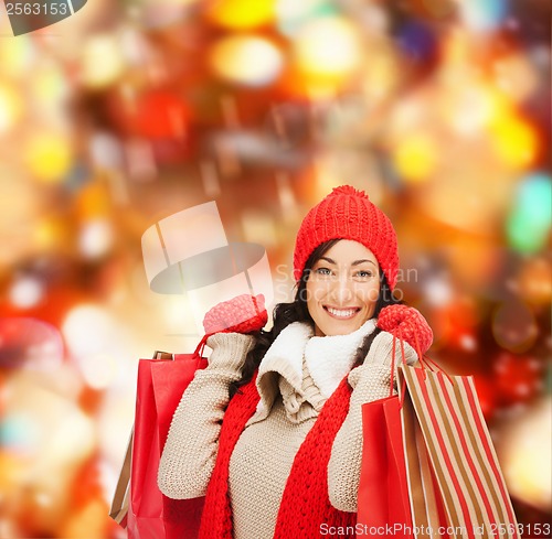 Image of smiling woman in warm clothers with shopping bags