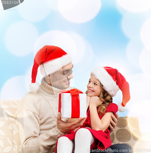 Image of smiling father giving daughter gift box