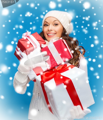 Image of woman in sweater and hat with many gift boxes