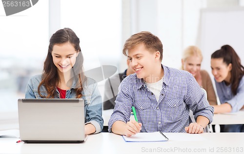 Image of students with laptop and notebooks at school