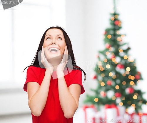 Image of amazed laughing young woman in red dress