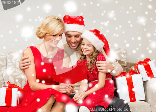 Image of smiling family reading postcard