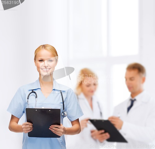 Image of smiling female doctor or nurse with clipboard