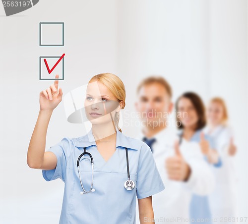 Image of smiling doctor or nurse pointing to checkmark