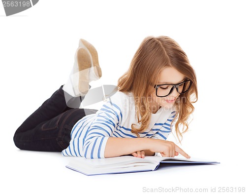 Image of smiling little student girl lying on the floor