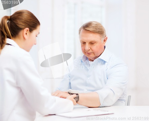 Image of female doctor or nurse measuring blood pressure