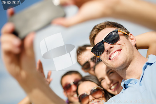 Image of group of friends taking picture with smartphone