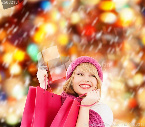 Image of woman in pink hat and scarf with shopping bags