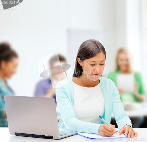 Image of asian businesswoman with laptop and documents