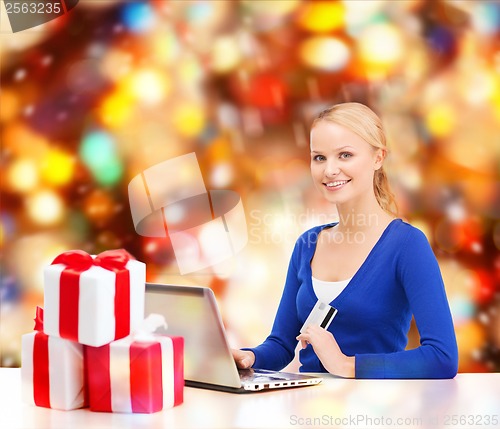 Image of woman with gifts, laptop computer and credit card