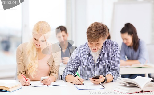 Image of students looking into smartphone at school