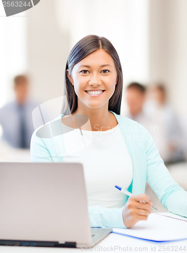 Image of asian businesswoman with laptop and documents