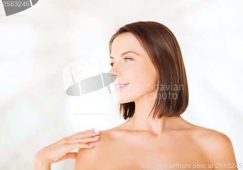 Image of beautiful woman touching her shoulders