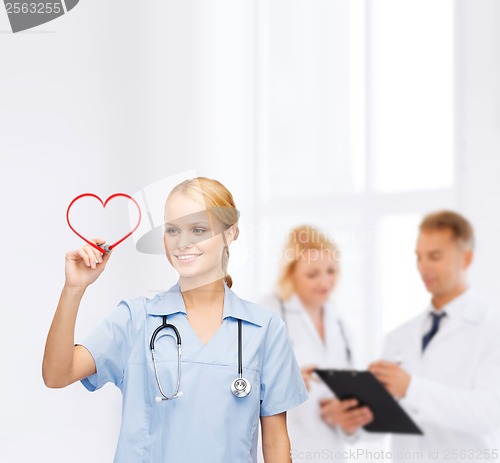 Image of smiling doctor or nurse drawing red heart