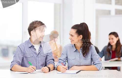 Image of two teenagers with notebooks at school