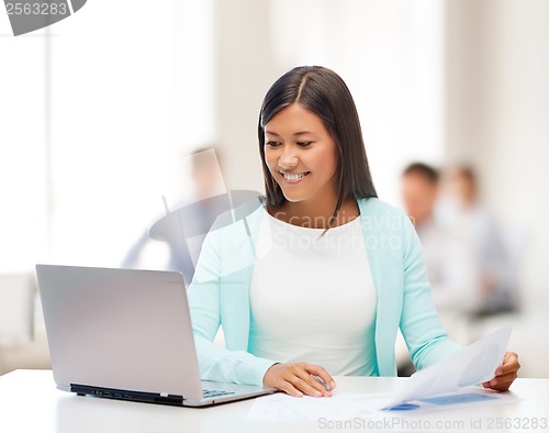 Image of asian businesswoman with laptop and documents