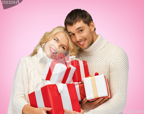Image of romantic couple in a sweaters with gift boxes