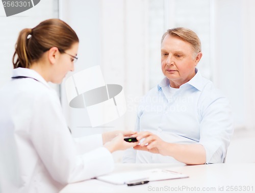 Image of female doctor or nurse measuring blood sugar value