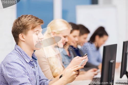 Image of students with computer monitor and smartphones