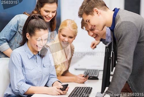 Image of students with computer monitor and smartphones