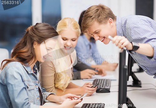 Image of students with computer monitor and smartphones