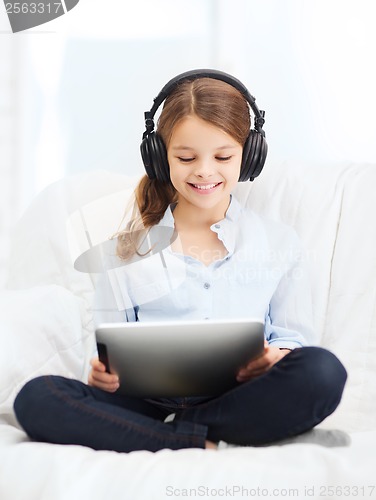 Image of girl with tablet pc and headphones at home