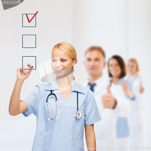 Image of doctor or nurse drawing checkmark into checkbox