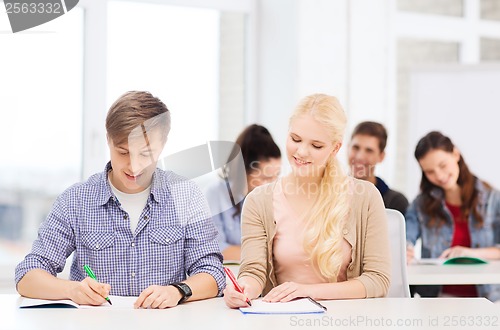 Image of two teenagers with notebooks at school