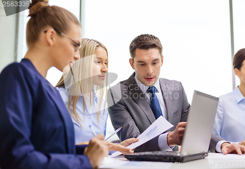 Image of business team with laptop having discussion