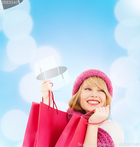 Image of woman in pink hat and scarf with shopping bags