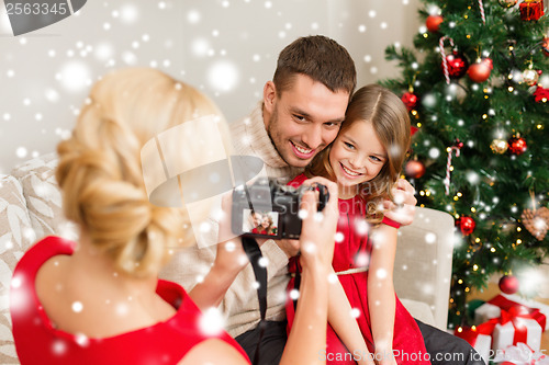 Image of mother taking picture of father and daughter
