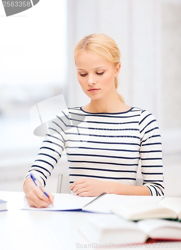 Image of concentrated woman studying in college
