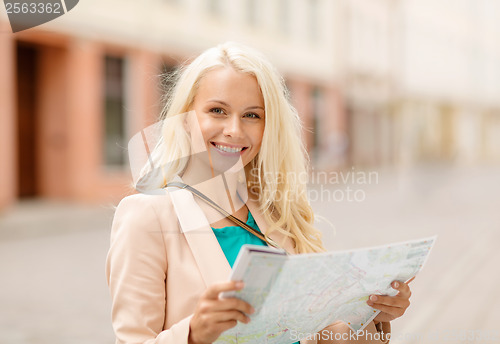 Image of smiling girl with tourist map in the city