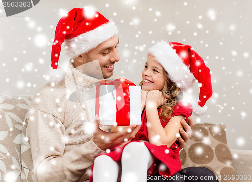 Image of smiling father giving daughter gift box