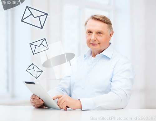 Image of old man with tablet computer at home