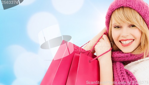 Image of woman in pink hat and scarf with shopping bags