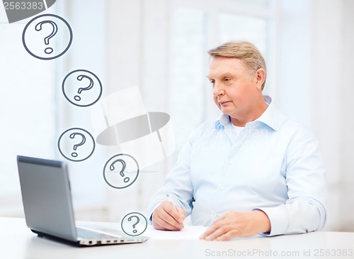 Image of old man filling a form at home