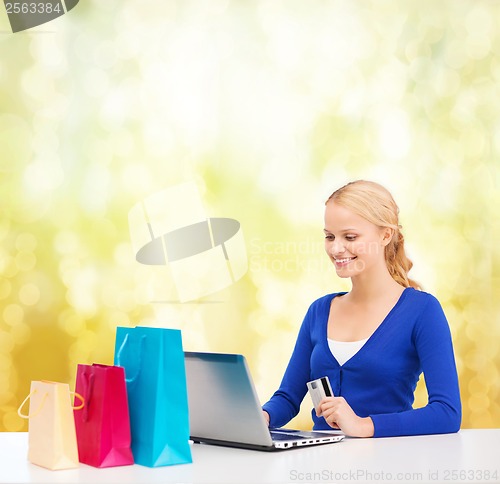Image of woman with laptop, shopping bags and credit card