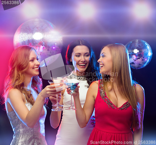 Image of three smiling women with cocktails and disco ball