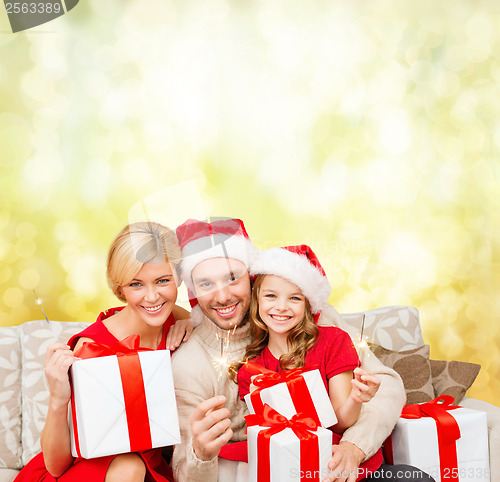 Image of smiling family holding gift boxes and sparkles