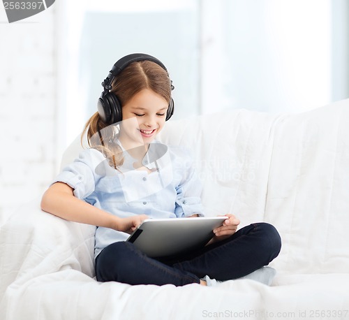 Image of girl with tablet pc and headphones at home