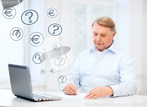 Image of old man filling a form at home