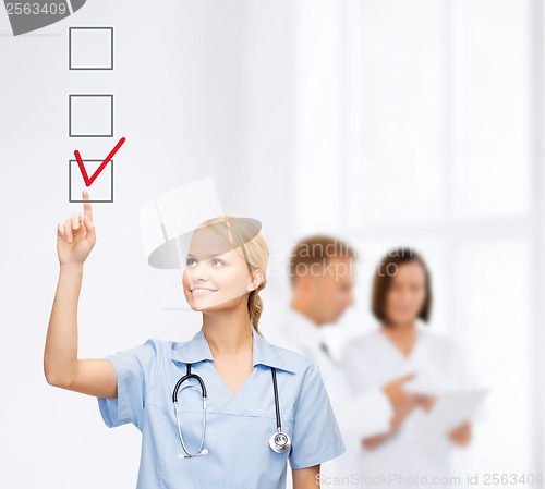 Image of doctor or nurse drawning checkmark into checkbox