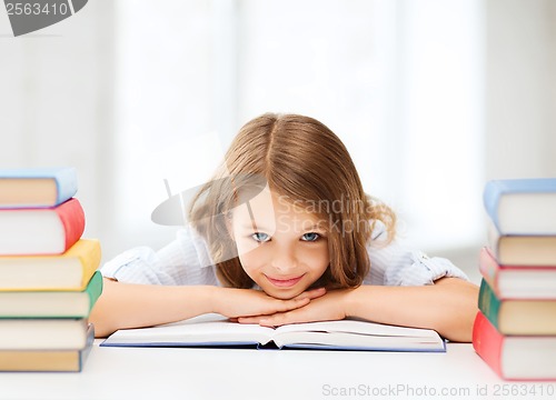 Image of pretty girl with many books at school